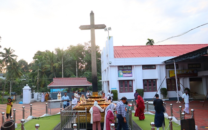 Lighting row of lights around the stone cross. (Chuttuvilakku)